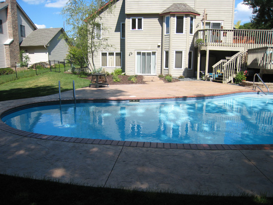 A finished pool renovation with new surface and landscaping.