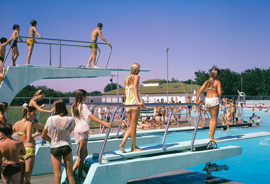 A vintage Twin Cities backyard pool with diving boards on a bright summer afternoon.